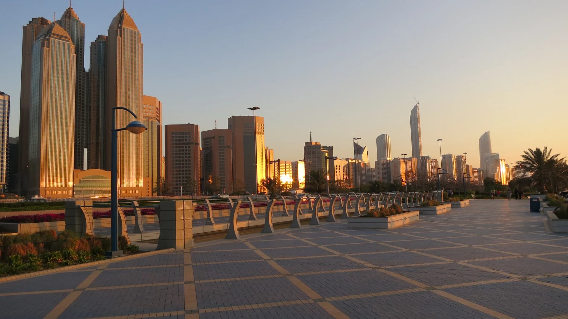 Abu Dhabi Corniche skyline at sunset, seen from the waterfront promenade