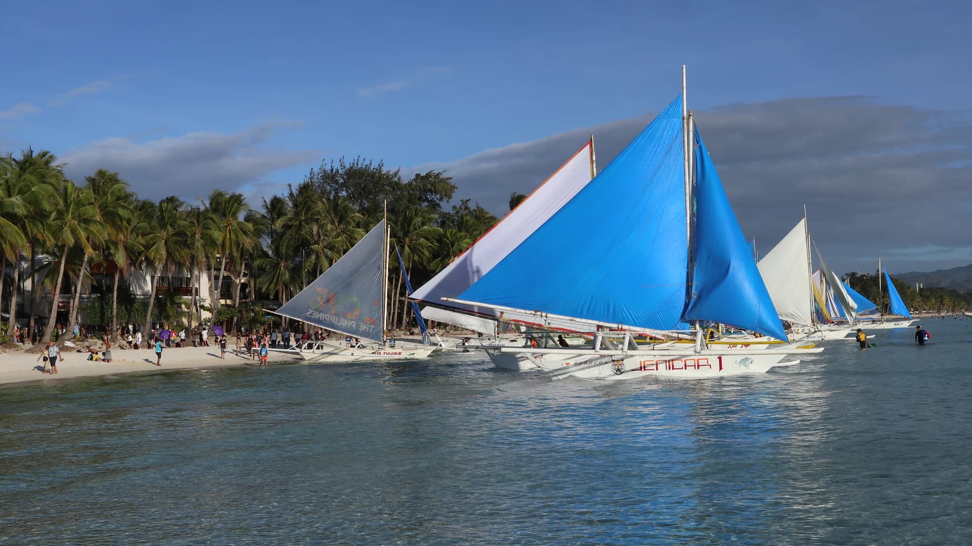 Paraw sailboats with twin outriggers drawn up on White Beach, Boracay, Philippines