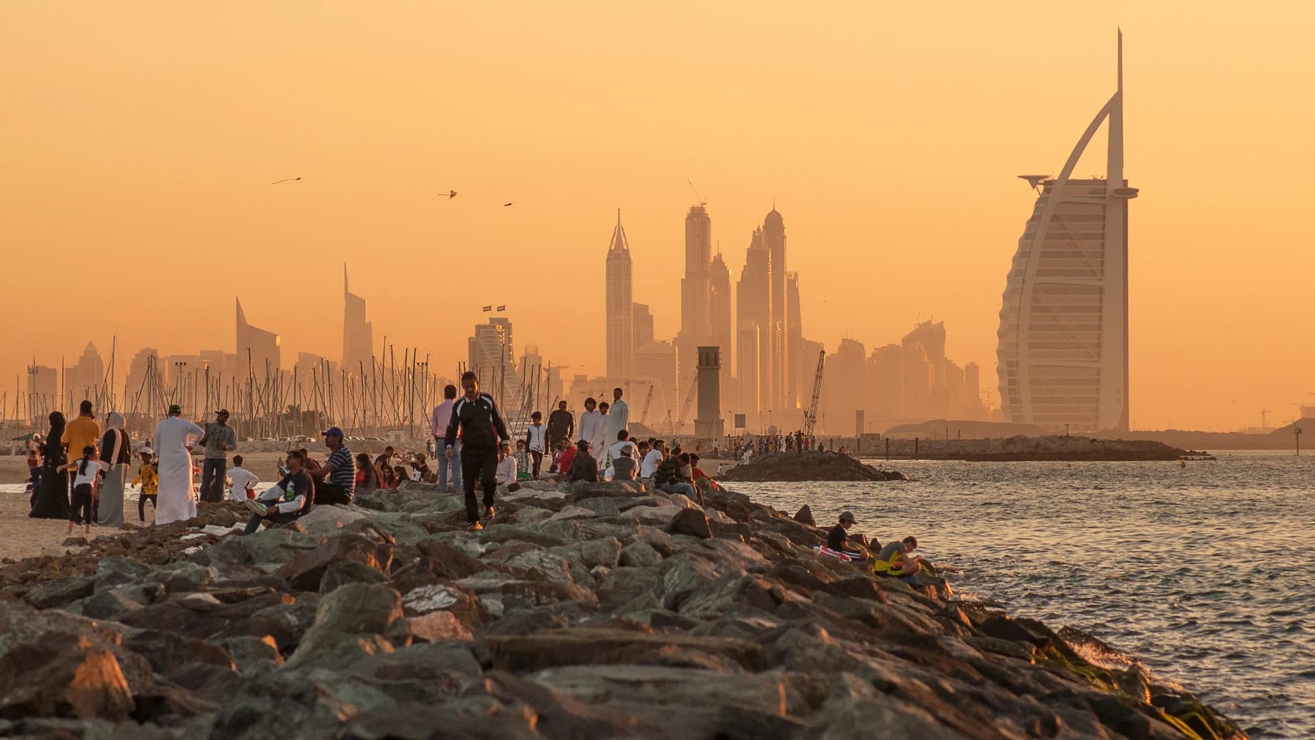 Burj Al Arab and the Dubai Marina skyline at sunset, seen from Jumeirah Beach