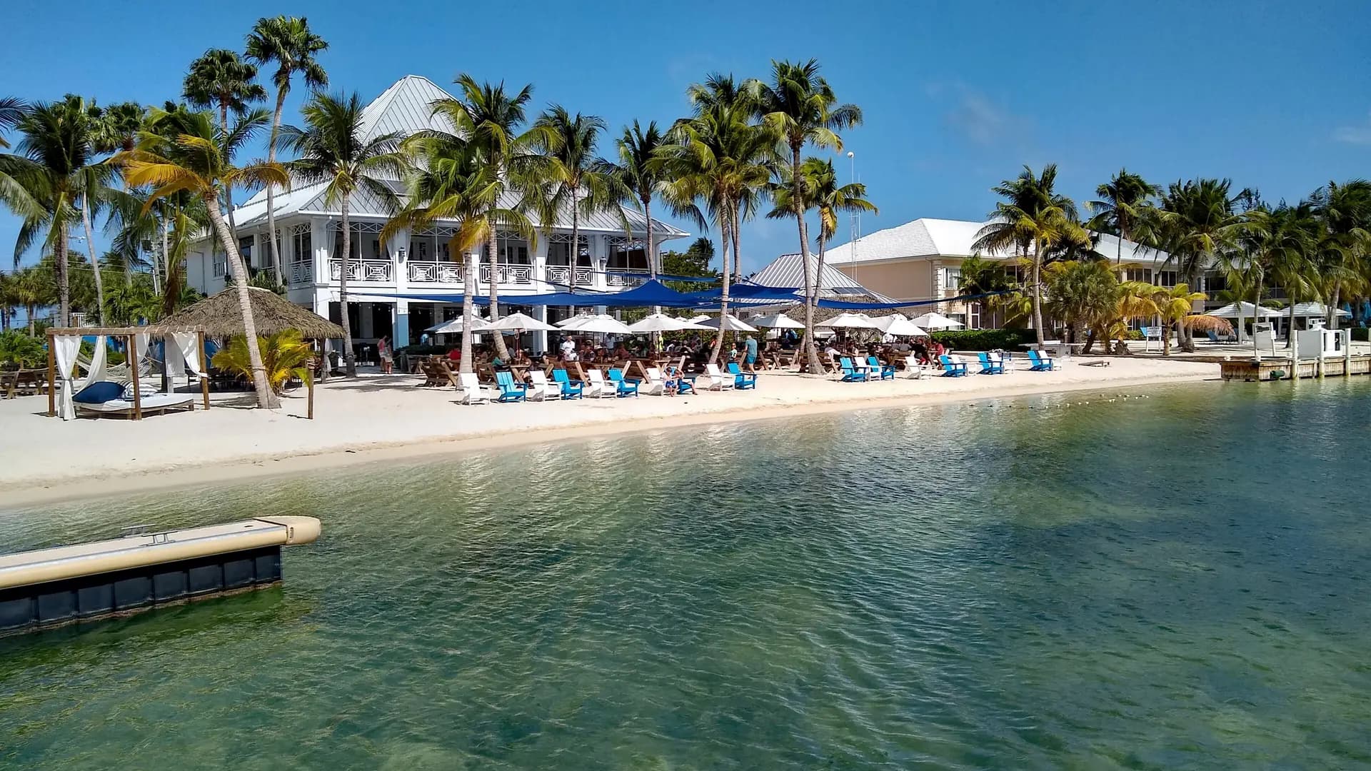 Kaibo Beach on Grand Cayman's North Side, with palm trees, loungers, and calm turquoise water