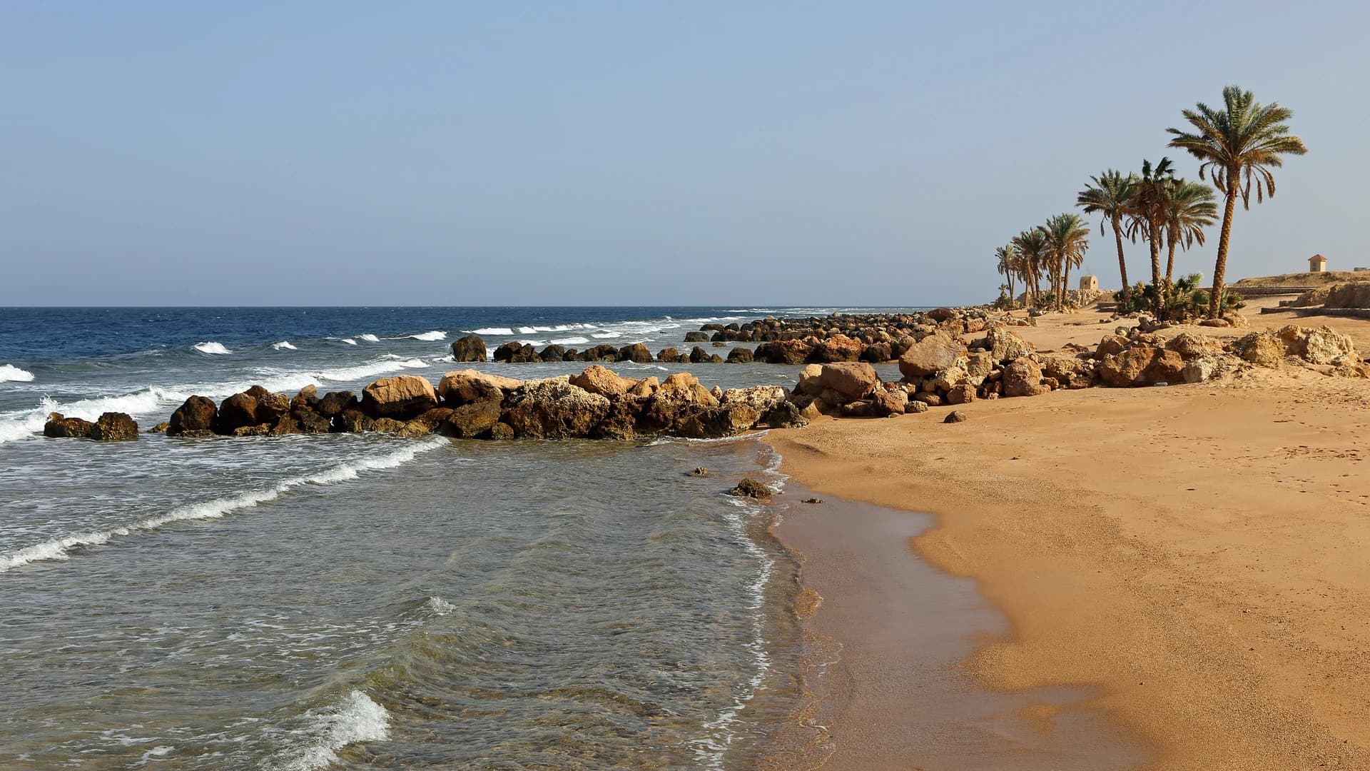 A quiet rocky beach with palm trees near Sahl Hasheesh, Hurghada, Egypt
