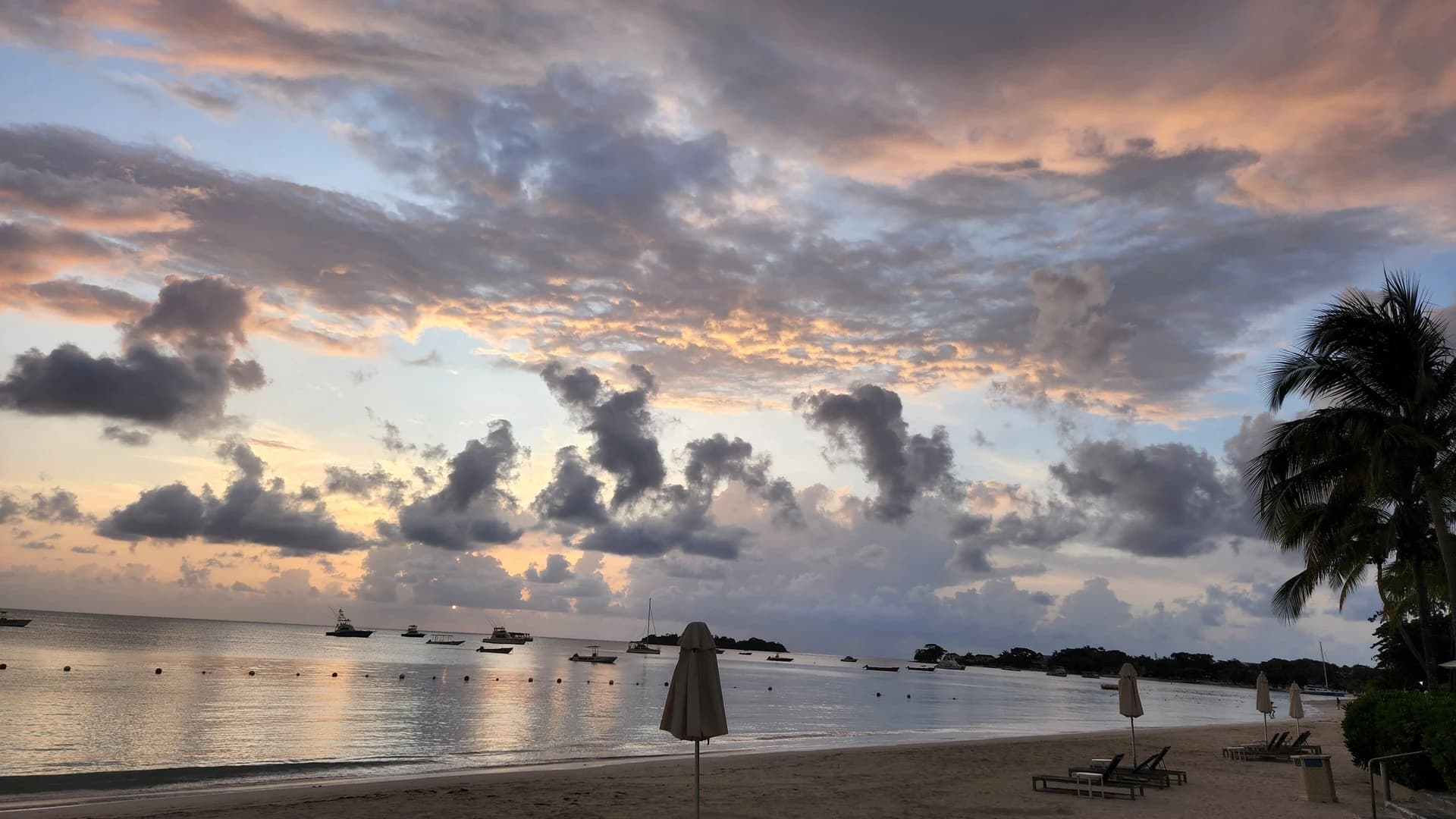 Sunset over the calm water and white sand of Seven Mile Beach, Negril, Jamaica
