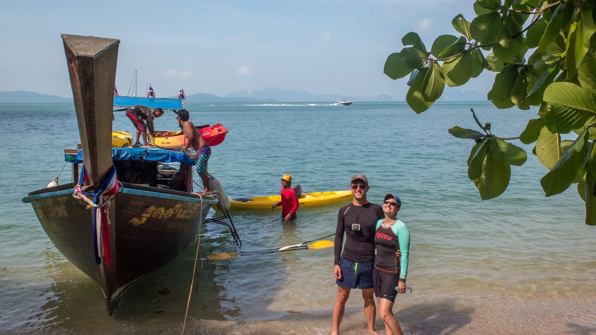 Sea canoes and a longtail boat launching into Phang Nga Bay, Thailand