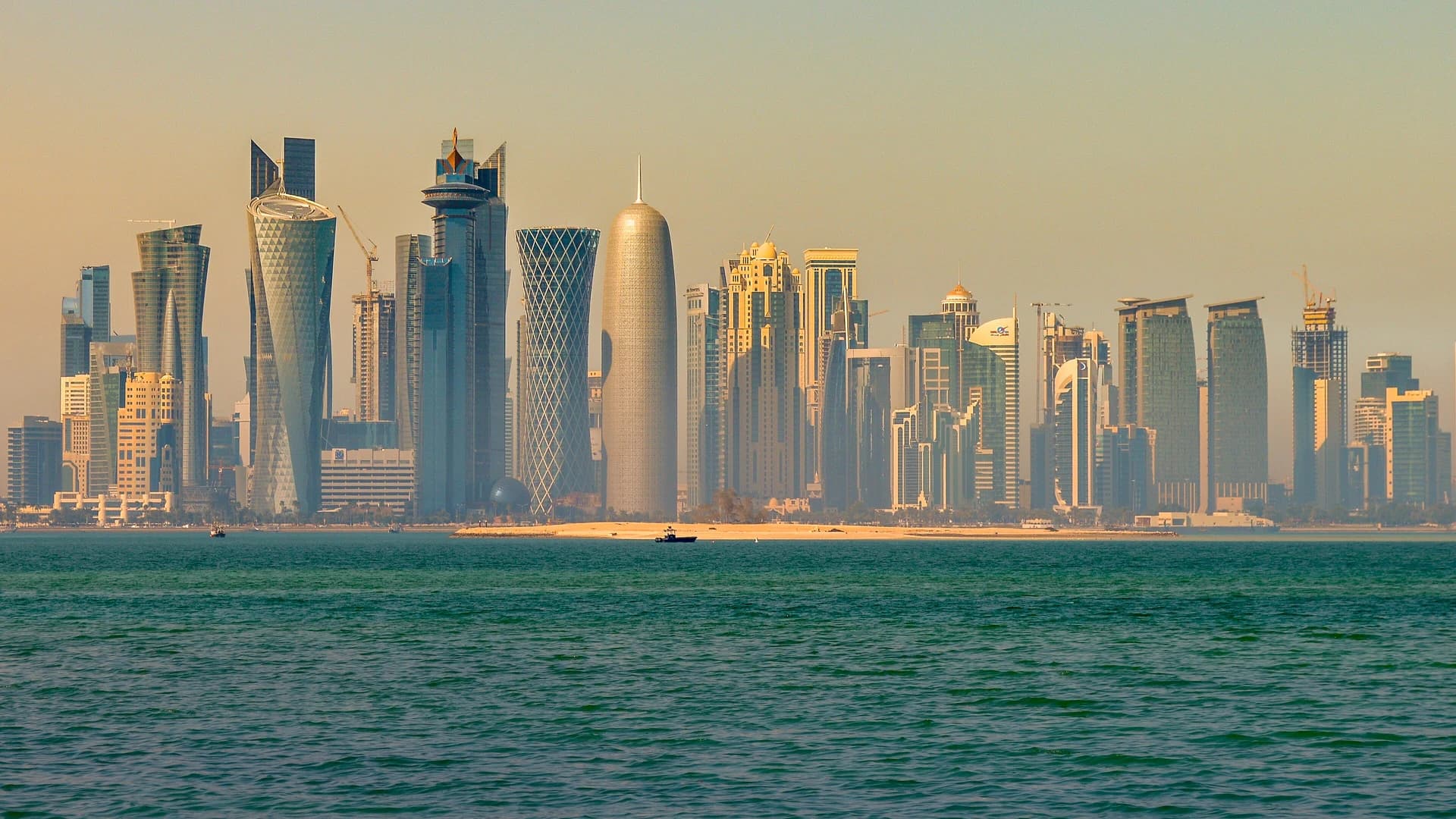 The Doha skyline seen across the water at sunrise, Qatar