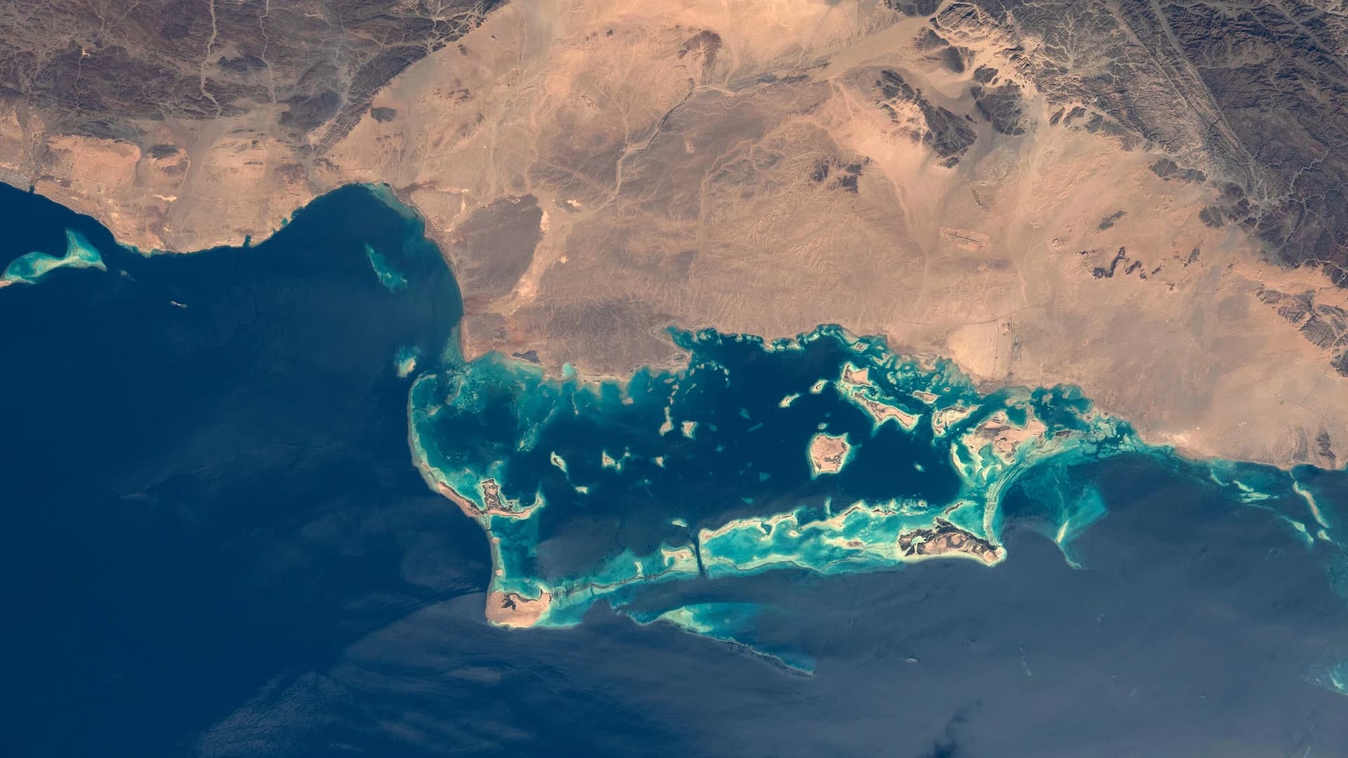 Turquoise coral reef lagoons along Saudi Arabia's Red Sea coast, seen from orbit