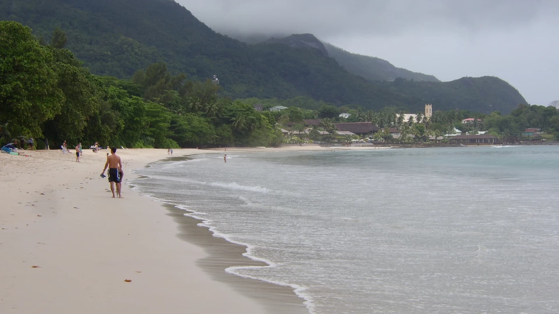 Beau Vallon beach with white sand and a forested mountain backdrop on Mahé, Seychelles
