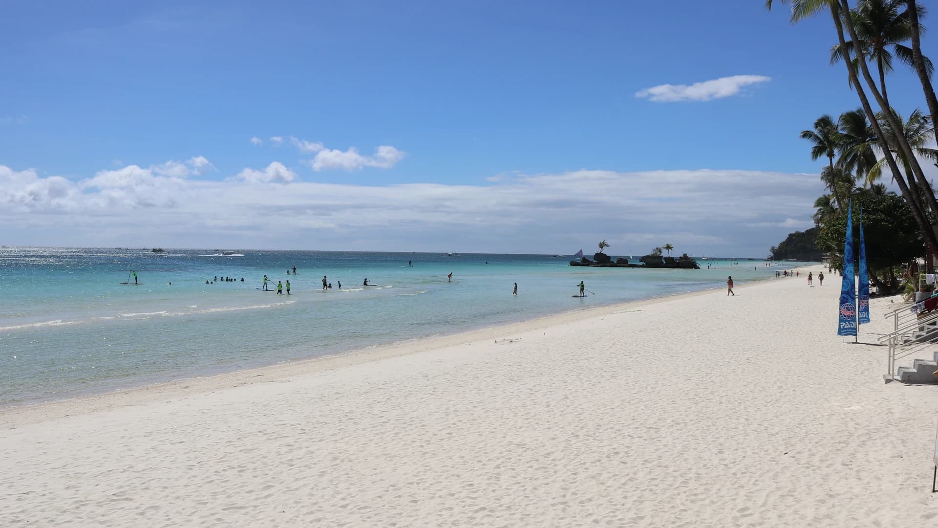 White Beach Station 1, Boracay, Philippines, with paddleboarders in the shallows