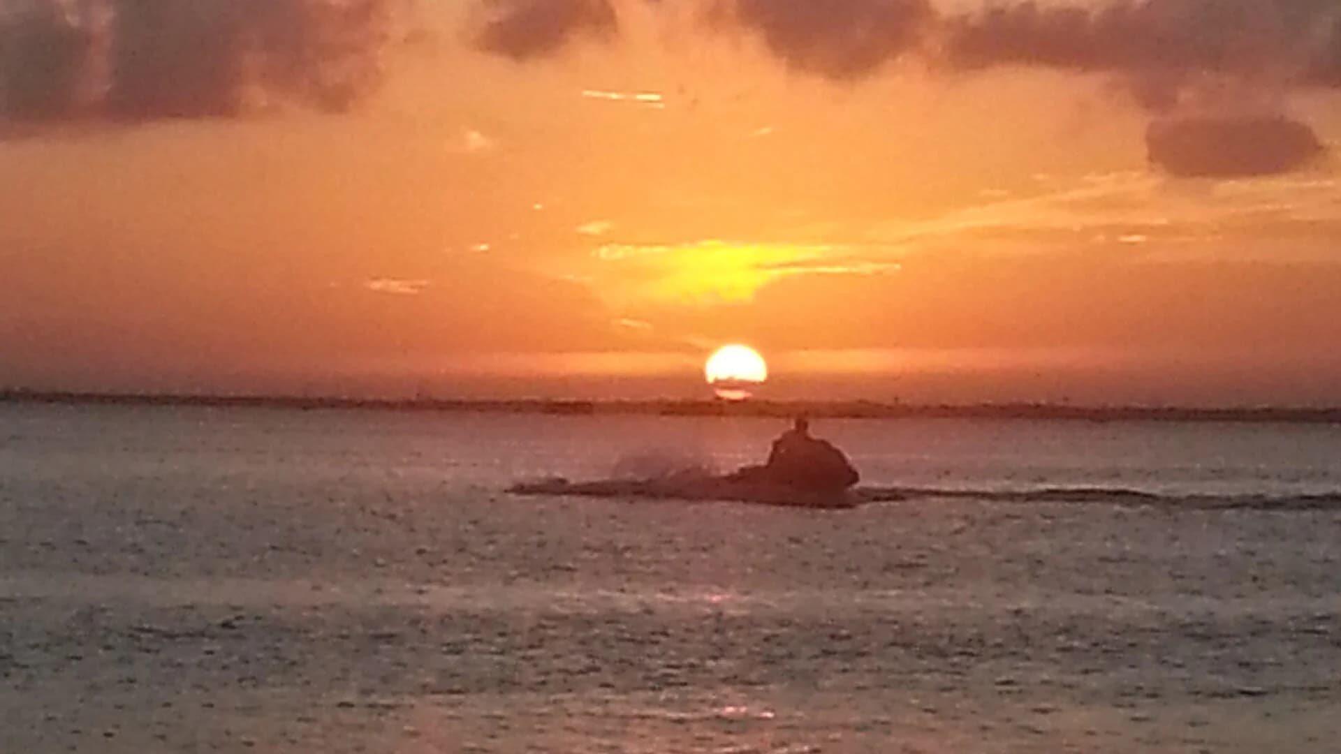 A jet ski silhouetted against the sunset on the water at Cancún, Mexico