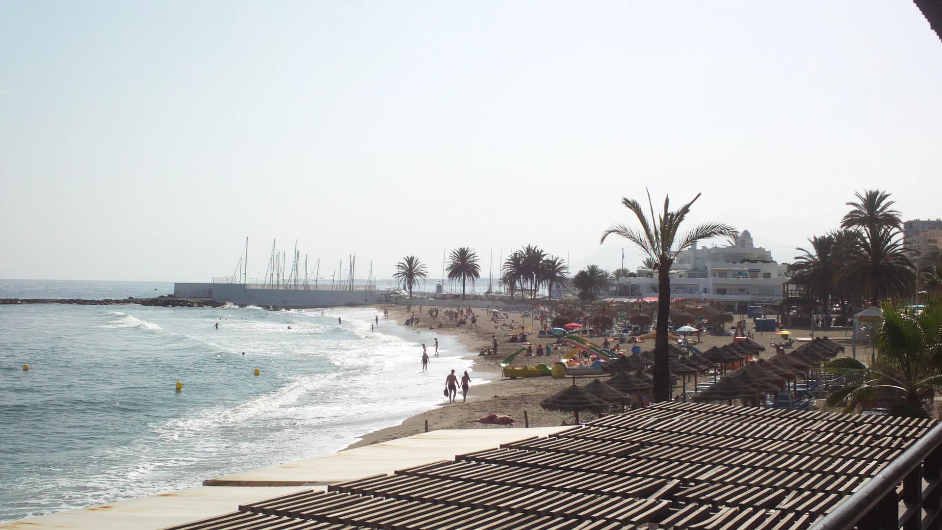 Marbella beach promenade with palm trees and a marina in the background, Costa del Sol