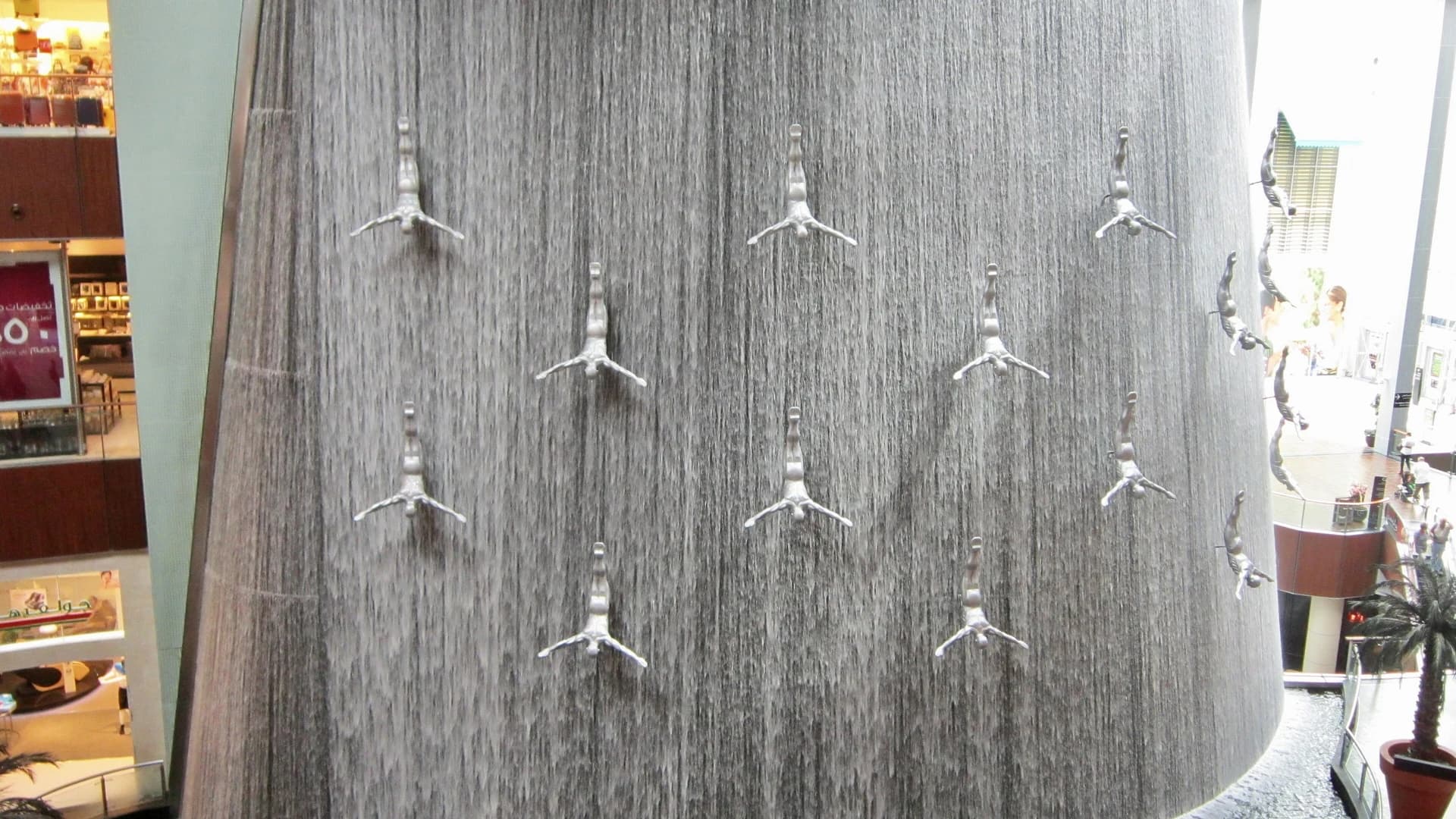 The waterfall fountain with diving figure sculptures at The Dubai Mall