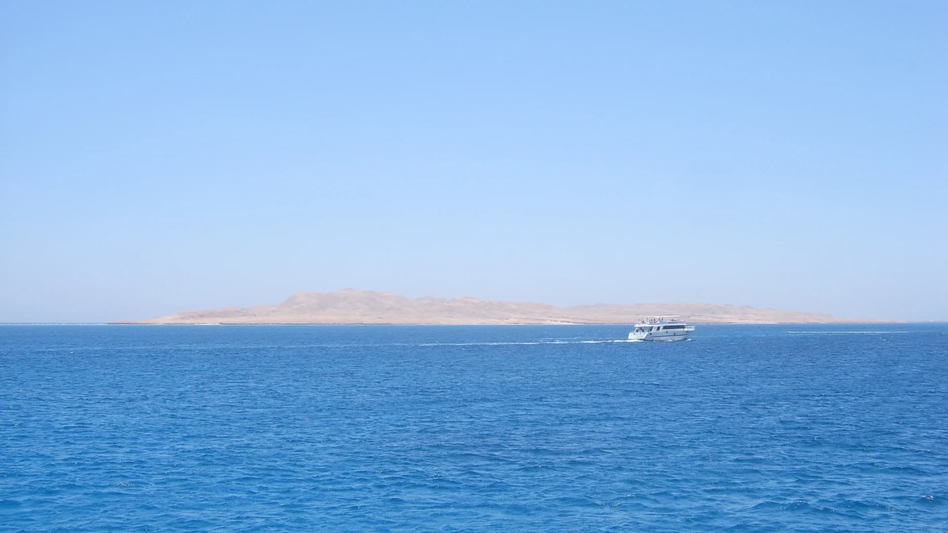 A tour boat passing Giftun Soraya island in the Red Sea off Hurghada, Egypt