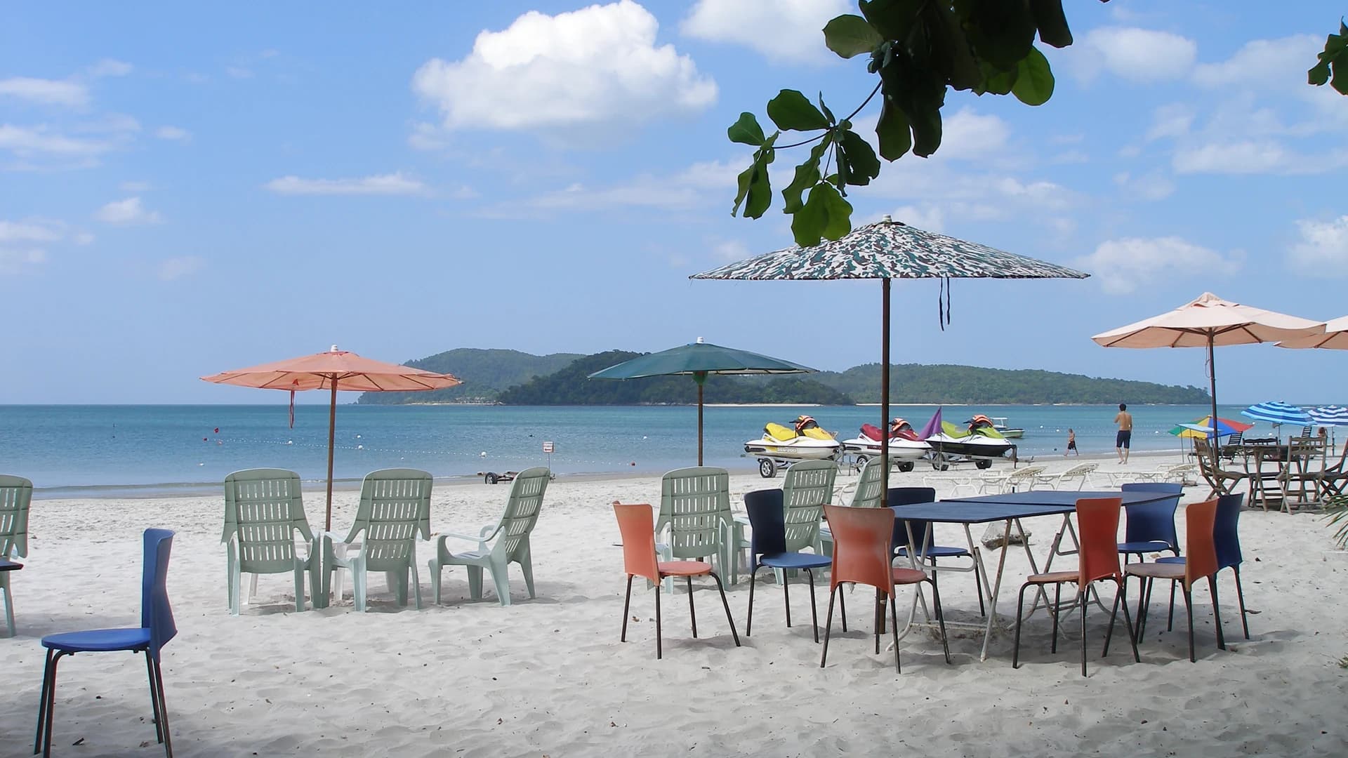 Beach umbrellas and chairs on the sand at Pantai Cenang, Langkawi, Malaysia