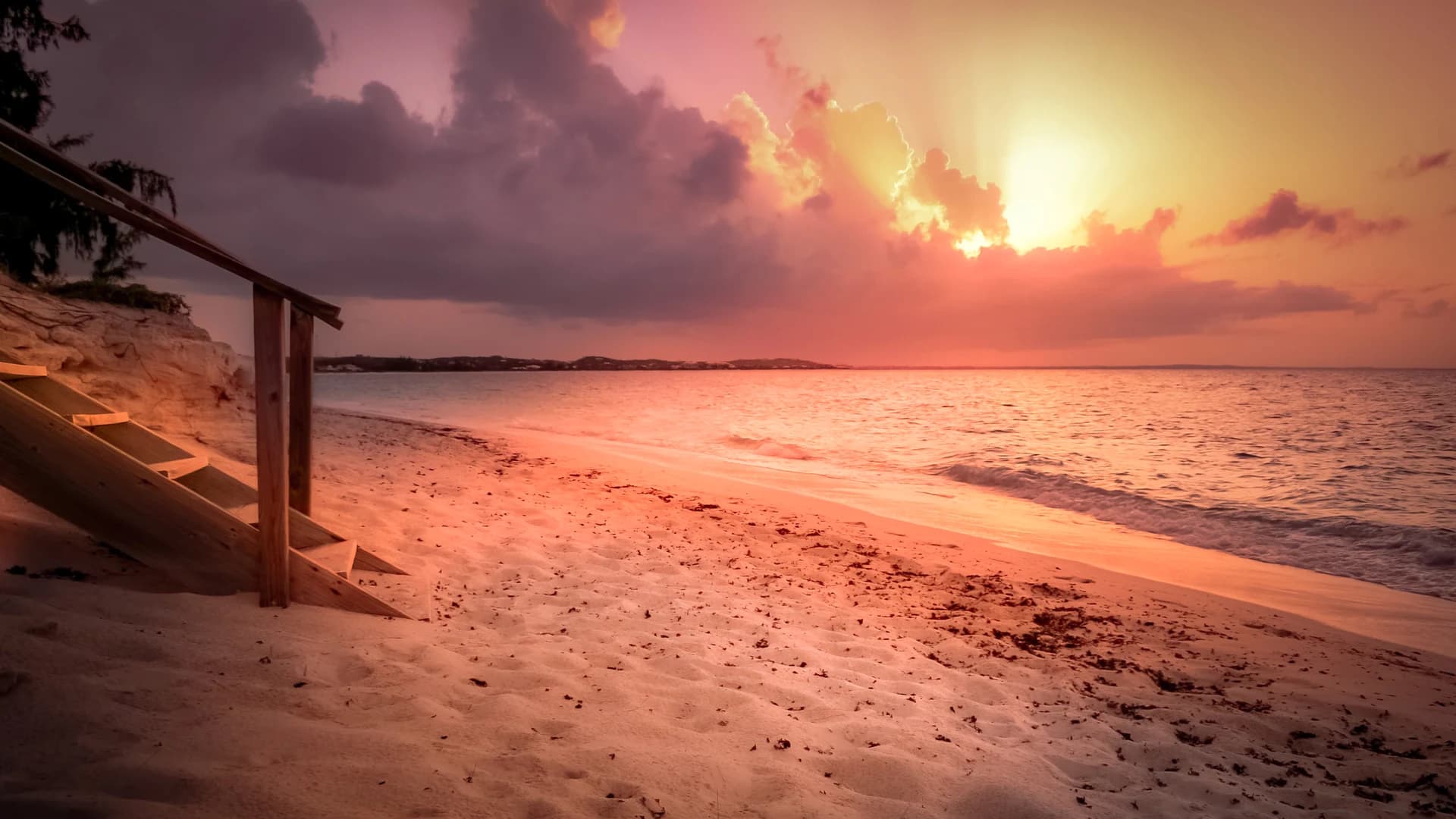 Sunset over the sand and turquoise water at Grace Bay Beach, Turks and Caicos