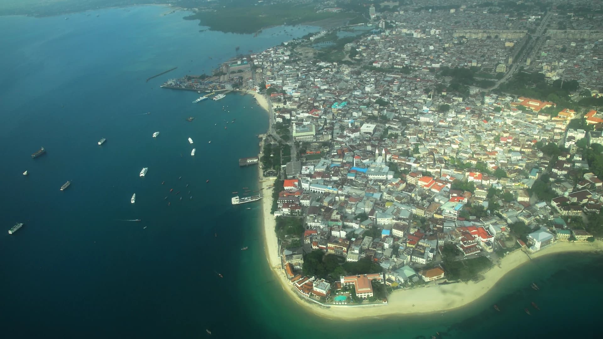 Aerial view of Stone Town's coastline and turquoise water, Zanzibar, Tanzania